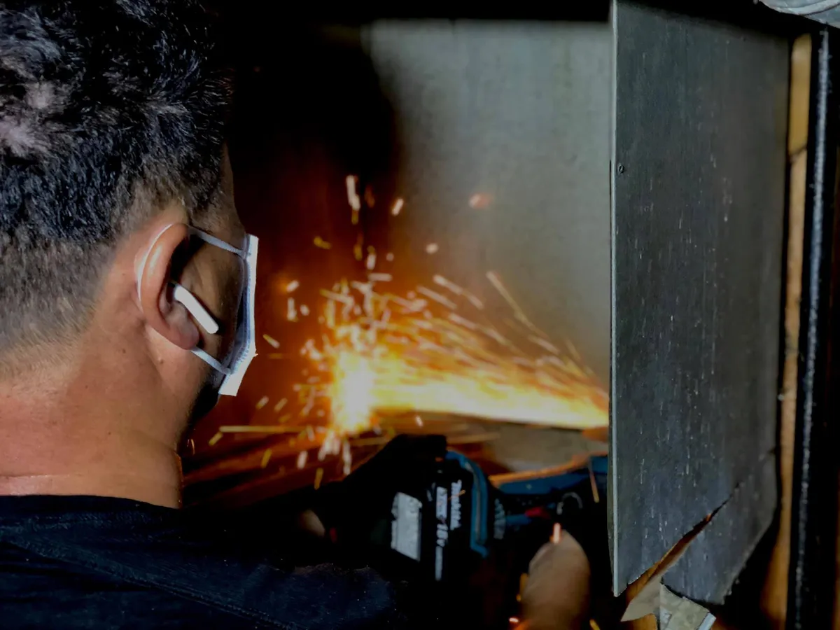 two men carrying a metal sheet